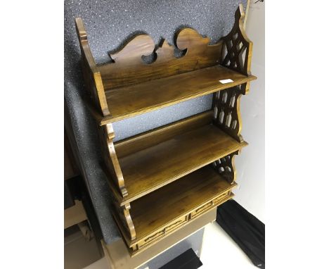 An ornate mahogany wall hanging shelf with drawers