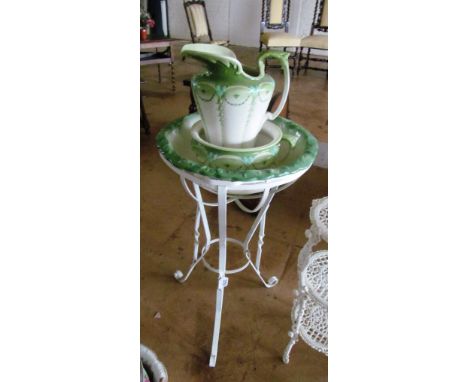 A white painted metal washstand with green pottery wash set and other basin and rose decorated bowl