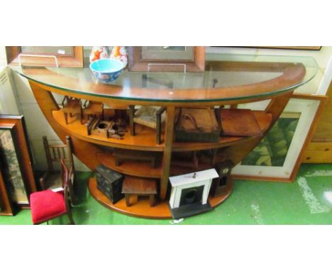 A semi-circular three tier glass shelf unit
