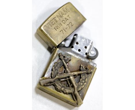 Zippo brass lighter inscribed Vietnam Nui Dat and dated 71-72, with applied part cap-badge, having further inscription verso.