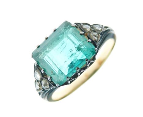 Late Victorian emerald and diamond ring the step cut set across the finger, measuring 9.6mm x 8.3mm x 4.9mm deep, with a trio