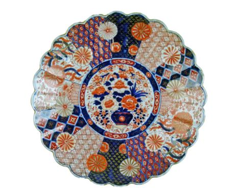 Imari porcelain charger decorated in iron-red, blue, white and gilt with a central panel depicting a vase of flowers within a