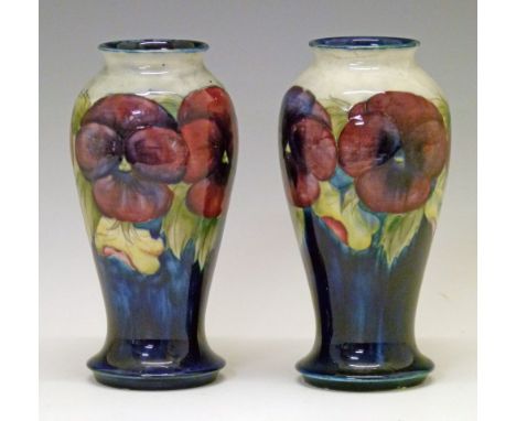 Pair of William Moorcroft 'Pansy' vases of baluster form, each decorated with stylised foliage on a blue and off-white ground