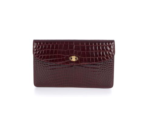 Celine, a crocodile embossed leather clutch, featuring a patent burgundy, crocodile embossed leather exterior, with the maker