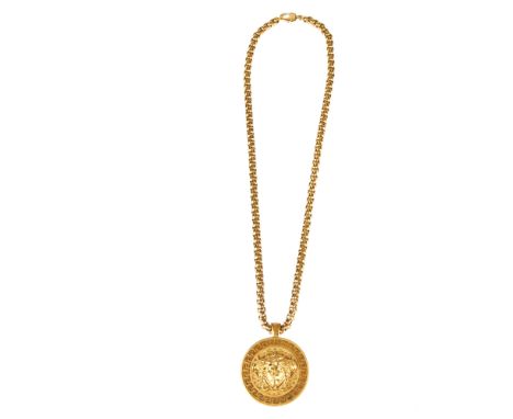 Versace, a Medusa pendant, crafted from gold-tone metal, featuring a large medusa head at the centre with Greek key surround,