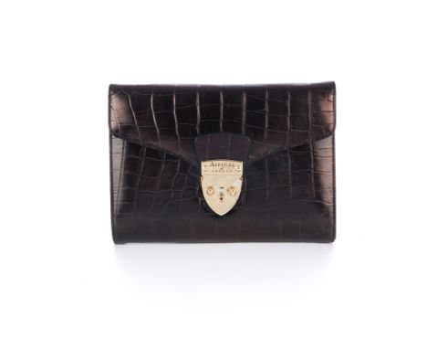Aspinal of London, a crocodile embossed leather clutch, featuring polished gold-tone hardware, shield lock front fastening an