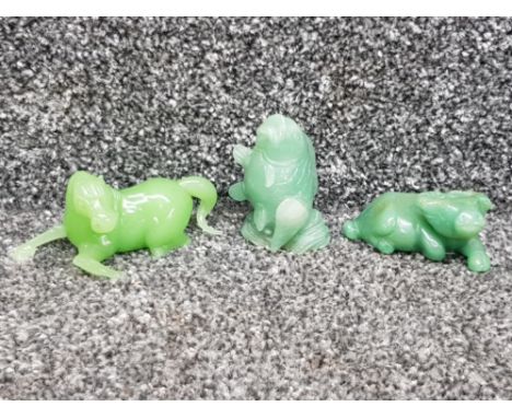 Three jade carvings of a horse, buffalo and a fish.
