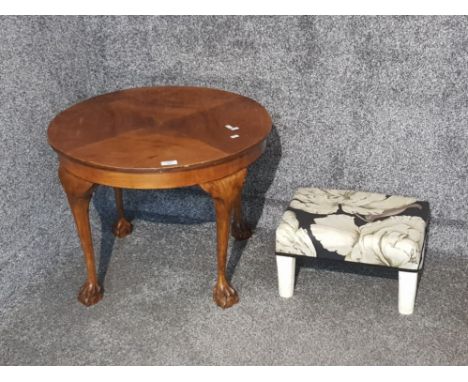 A circular lamp table and a footstool upholstered in floral patterned material.