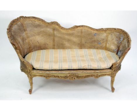 GOOD EARLY TWENTIETH CENTURY LOUIS XV STYLE FRENCH CARVED GILTWOOD TWO SEATER BERGERE SETTEE, the scroll carved show wood fra