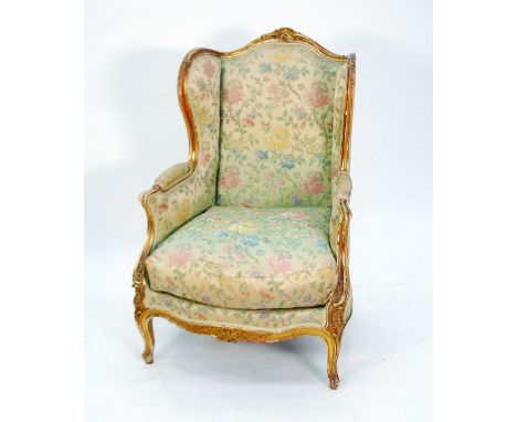 GOOD QUALITY EARLY TWENTIETH CENTURY FRENCH CARVED GILTWOOD WINGED EASY ARMCHAIR, the moulded show wood frame with shell carv