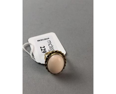 CORAL DRESS RING, the cabochon oval stone set in eighteen carat gold