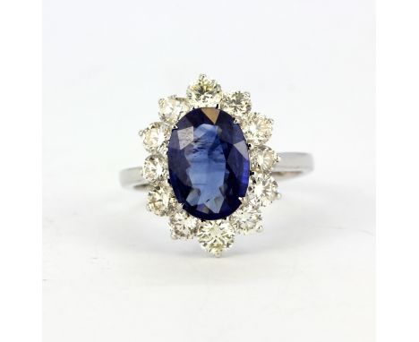 An 18ct white gold (stamped 750) cluster ring set with an oval cut sapphire and diamond set shoulders, sapphire approx. 2,87c
