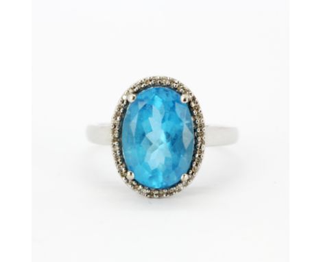 A 9ct white gold ring set with a large oval cut blue topaz and diamonds, (U).