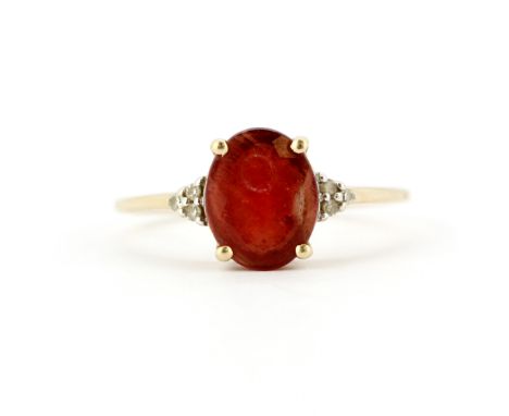 A 9ct yellow gold ring set with oval cut cornelian and diamond set shoulders, (T.5).