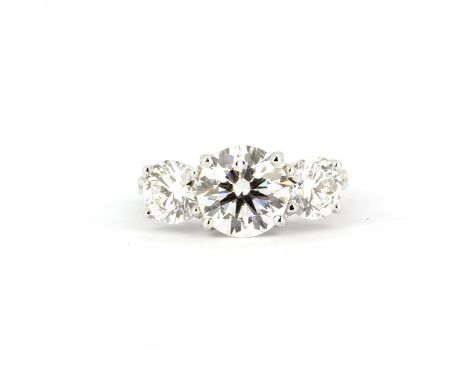 An 18ct white gold (stamped 750) ring set with three brilliant cut CVD diamonds, centre stone 2.85ct, sides 0.96ct each, shou