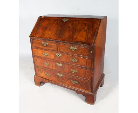 AN 18TH CENTURY WALNUT BUREAU with fall front, fitted interior on two short and three long graduated drawers with brass handl