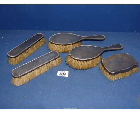 Two silver backed hairbrushes with two matching clothes brushes, date letter 'O' possibly 1913, Birmingham, having engine tur