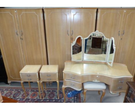 A 1960's limed walnut 7 piece bedroom suite comprising 2 double wardrobes, fitted wardrobe, dressing table and stool, 2 bedsi