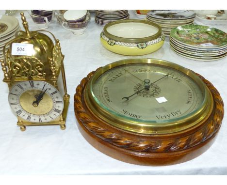 A circular aneroid barometer in carved rope twist frame; a reproduction brass lantern clock with battery movement