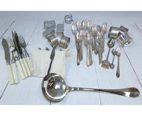 Seven various hallmarked silver napkin rings; a silver plated soup ladle and cutlery; a wirework basket; etc.