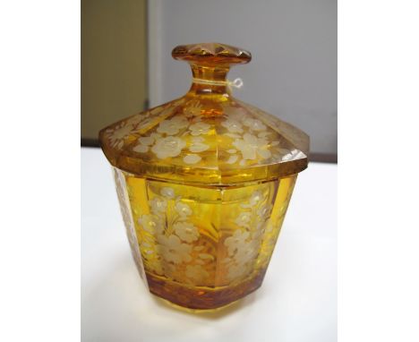 An Early XX Century Octagonal Amber Glass Jar and Cover, in the Moser style, with wheel cut floral decoration to each panel, 