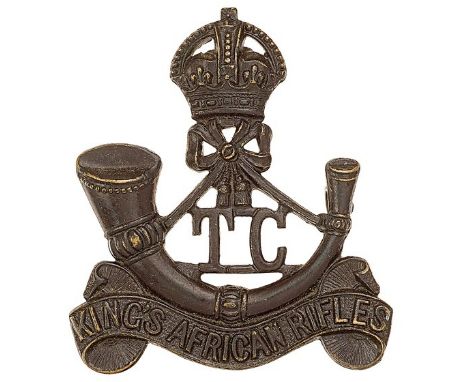 King’s African Rifles scarce Training Company pre 1953 cap badge.Die-cast blackened brass crowned strung bugle on title scrol
