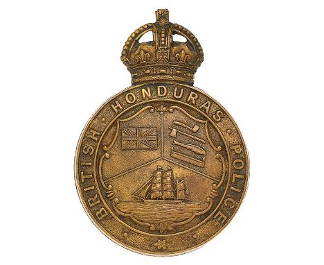 British Honduras Police pre 1953 helmet plate.Die-stamped brass crowned title circlet; central rococo shield divided in three