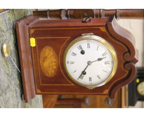 An Edwardian inlaid mahogany mantel clock, the swan neck pediment case with shell motif on brass bun feet, the enamel dial wi