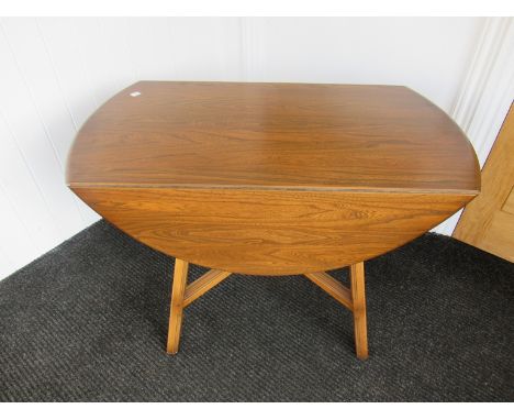 An Ercol drop leaf dining table together with four 'Swan' chairs'.