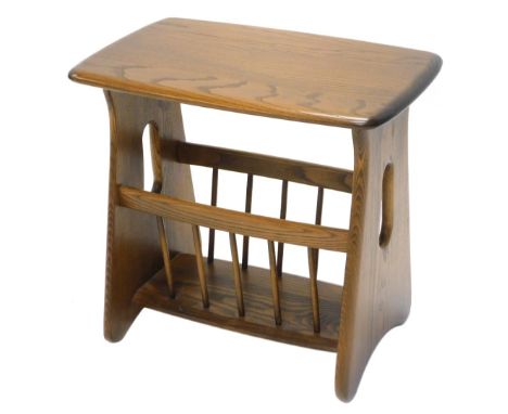 An Ercol mid coloured elm Canterbury, the rectangular top with rounded edges and corners, on pierced end supports, 52cm wide.