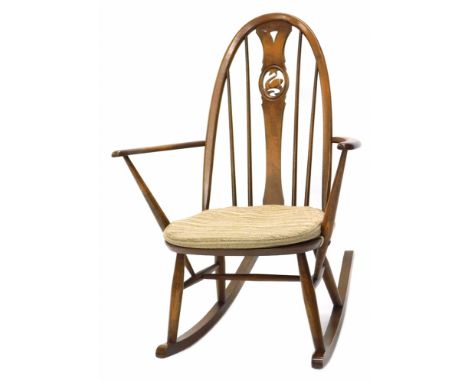 An Ercol mid stained beech rocking chair, the back with pierced decoration of a swan, on turned supports. The upholstery in t