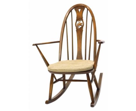 An Ercol mid stained beech rocking chair, the back with pierced decoration of a swan, on turned supports. The upholstery in t