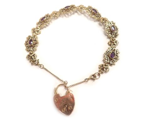 A 9ct gold gate bracelet, floral scroll design, set with oval amethyst, with extender chain and heart shaped padlock, 22cm lo