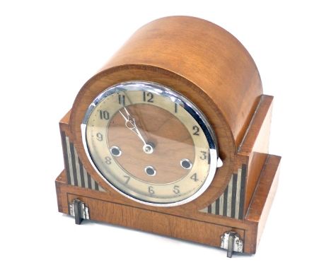 An Art Deco oak cased mantel clock, the arched top above a chrome and silvered dial, with striped and panelled side, on brack