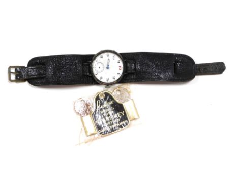 A wristwatch, the circular watch head with white enamel numeric dial, in a white metal case, unmarked, 3cm diameter, on a bla
