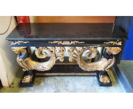 CONSOLE TABLE, ebonised and giltwood with black marble top above mirrored base with wyvern supports, 83cm Hx 140cm W x 52cm D