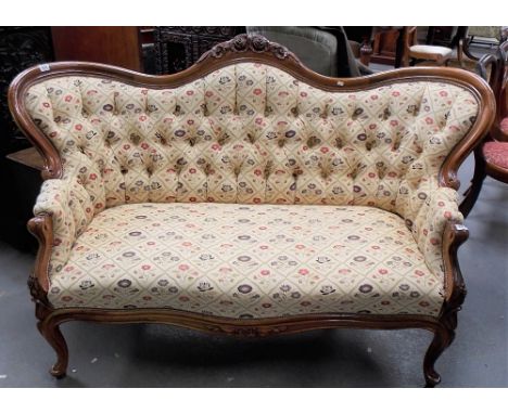 Victorian walnut framed button-back upholstered settee with foliate carved and upholstered arm rests over a stuff-over seat a