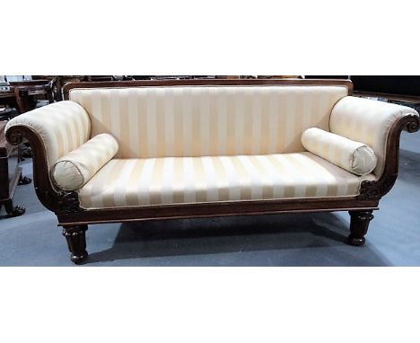 William IV mahogany upholstered settee with scroll leaf carved arms and raised on four turned and fluted legs, width 210cm