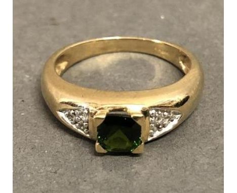 A 9ct. Gold Dress Ring set green stone flanked by diamond shoulders 