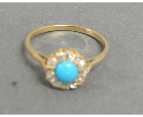 A Yellow Metal Dress Ring set with a central cabochon turquoise surrounded by diamonds within a pierced setting 