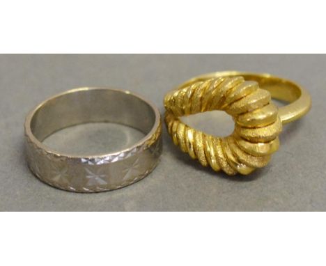 An 18ct. gold ring of shaped stylized form. 8.5 gms together with an 18ct. white gold band ring. 4.8 gms 