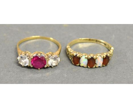 A 9ct. Yellow Gold Opal and Garnet Set Ring set with two opals and three garnets within a pierced setting together with anoth