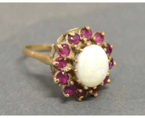 A 9ct. Yellow Gold Dress Ring set with large oval opal, surrounded by garnets within a pierced setting 