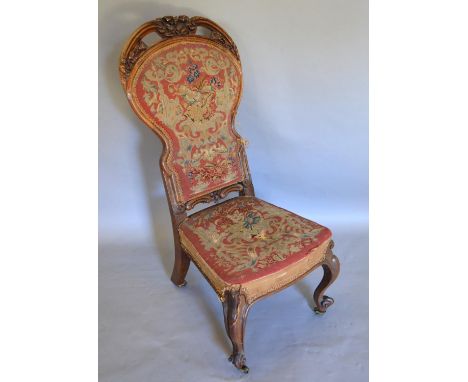 A Victorian Carved Walnut Low Seat Chair, the shaped carved and tapestry upholstered back above a similar seat raised upon ca