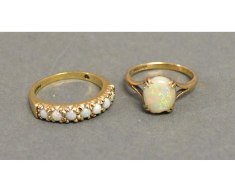 A 9ct. Yellow Gold Opal Set Ring together with another similar 9ct. gold ring set with seven opals 