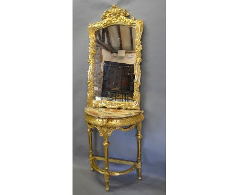 A Carved Gilt Wood Console Table of Demilune Form with a shaped carved mirror above a variegated marble top, raised upon turn