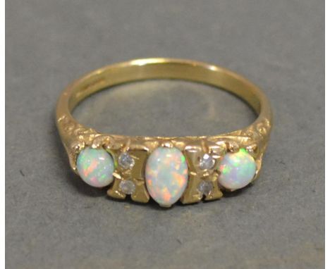 A 9ct. Gold Opal and Diamond Ring set with three opals interspaced with small diamonds 