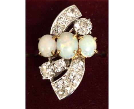 An 18ct. Gold Opal and Diamond Ring set with three large Cabochon Opal, flanked by Diamonds within a stylised form 