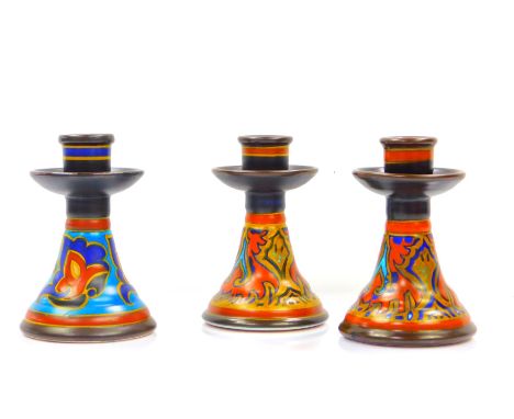 A pair of Gouda Pottery candlesticks, decorated in the Lurette patten, No 155, painted marks, 14cm H, and a further candlesti