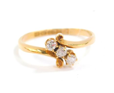 An 18ct gold and diamond three stone ring, in a cross over setting, approx 0.2cts, size R, 3.2g.